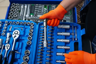 Photo of Auto mechanic with different tools at automobile repair shop, closeup