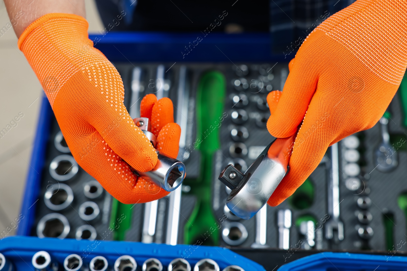 Photo of Auto mechanic with torque wrench and different tools at automobile repair shop, top view