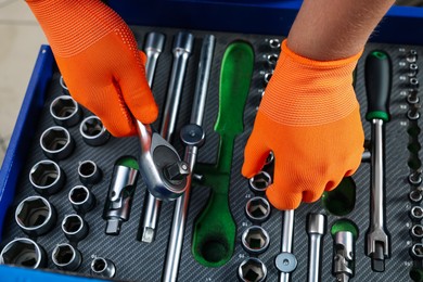 Photo of Auto mechanic with torque wrench and different tools at automobile repair shop, top view