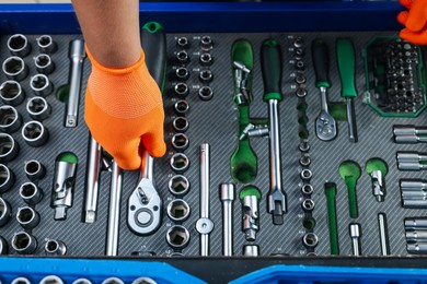 Photo of Auto mechanic with different tools at automobile repair shop, top view