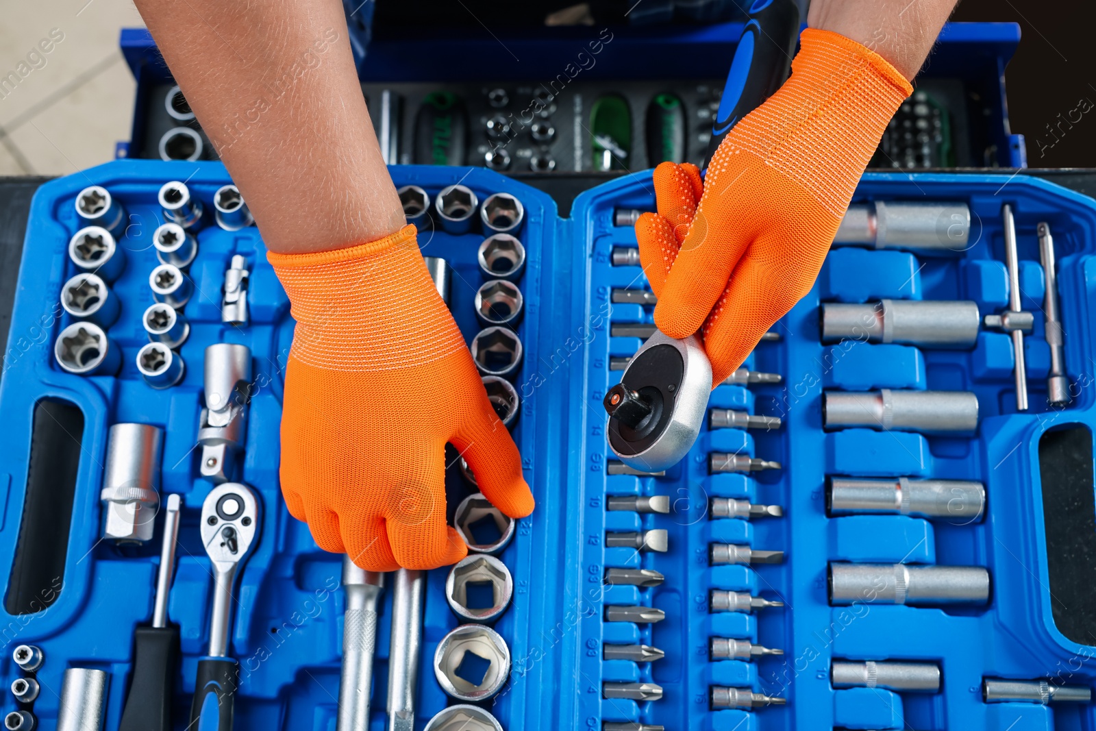 Photo of Auto mechanic with torque wrench and different tools at automobile repair shop, top view