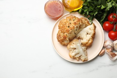 Delicious baked cauliflower and products on white table, flat lay. Space for text