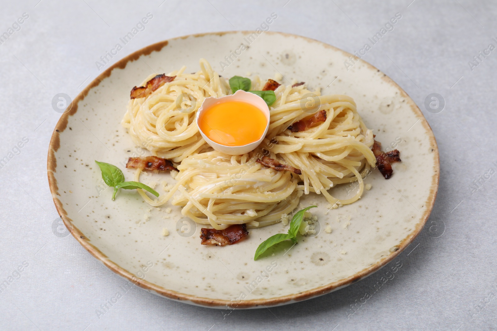 Photo of Delicious pasta Carbonara on grey table, closeup