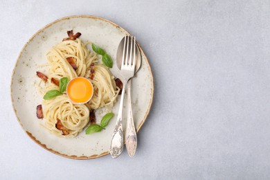 Photo of Delicious pasta Carbonara served on grey table, top view. space for text