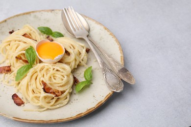 Delicious pasta Carbonara served on grey table, closeup