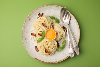 Delicious pasta Carbonara served on green background, top view