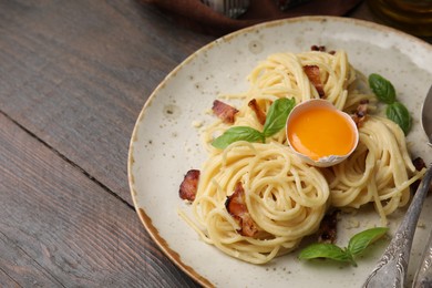 Delicious pasta Carbonara served on wooden table, closeup