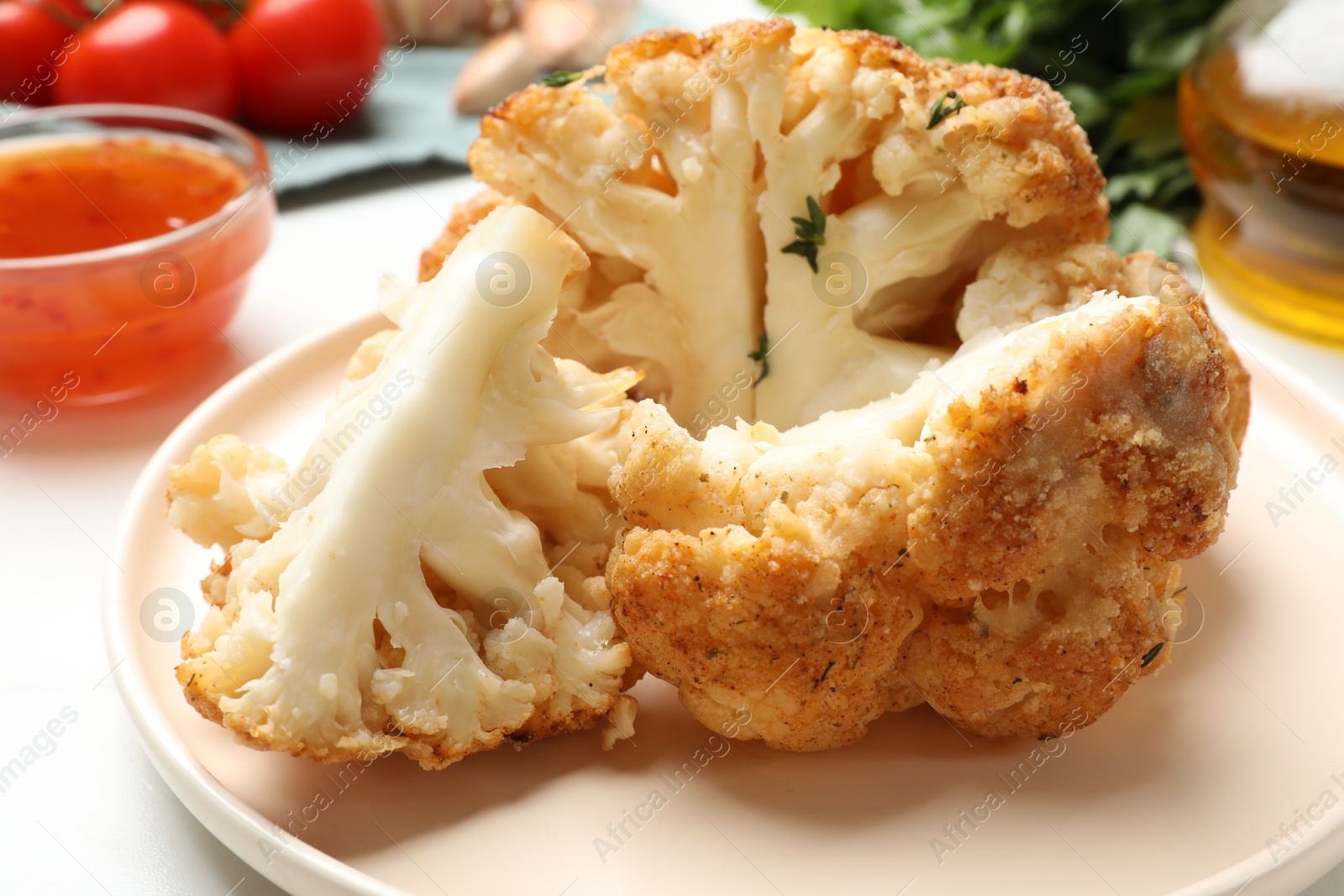 Photo of Delicious baked cauliflower on white table, closeup