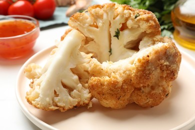 Photo of Delicious baked cauliflower on white table, closeup