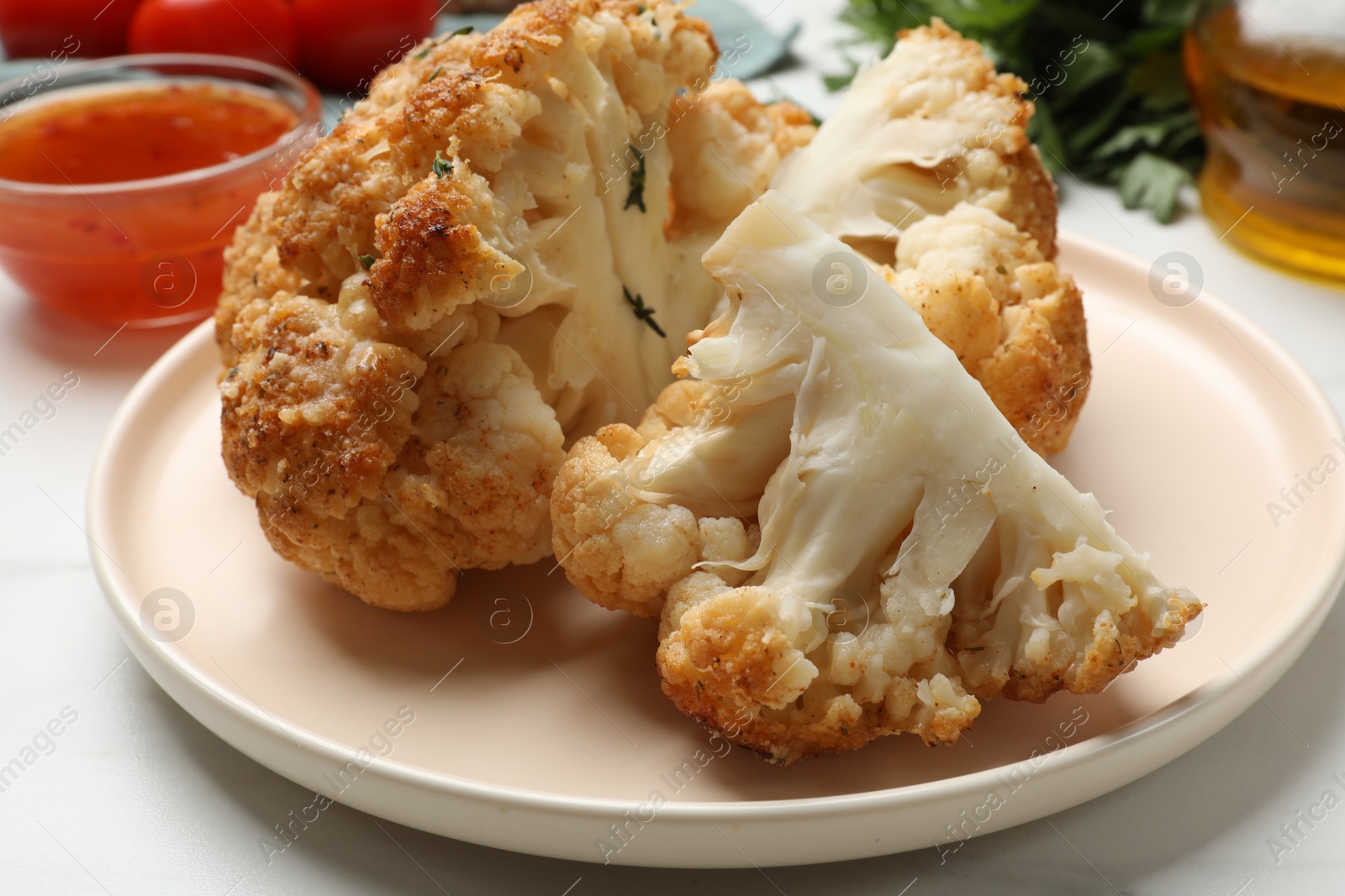 Photo of Delicious baked cauliflower on white table, closeup