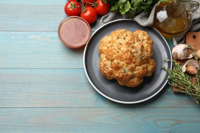 Delicious baked cauliflower and products on light blue wooden table, flat lay. Space for text