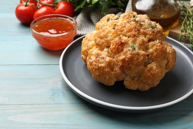 Delicious baked cauliflower and products on light blue wooden table, closeup