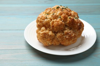 Photo of Delicious baked cauliflower on light blue wooden table