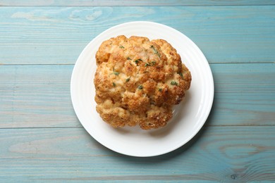 Photo of Delicious baked cauliflower on light blue wooden table, top view