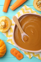 Photo of Delicious baby food in bowl and ingredients on light blue wooden table, flat lay