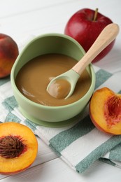 Photo of Delicious baby food in bowl and ingredients on white wooden table