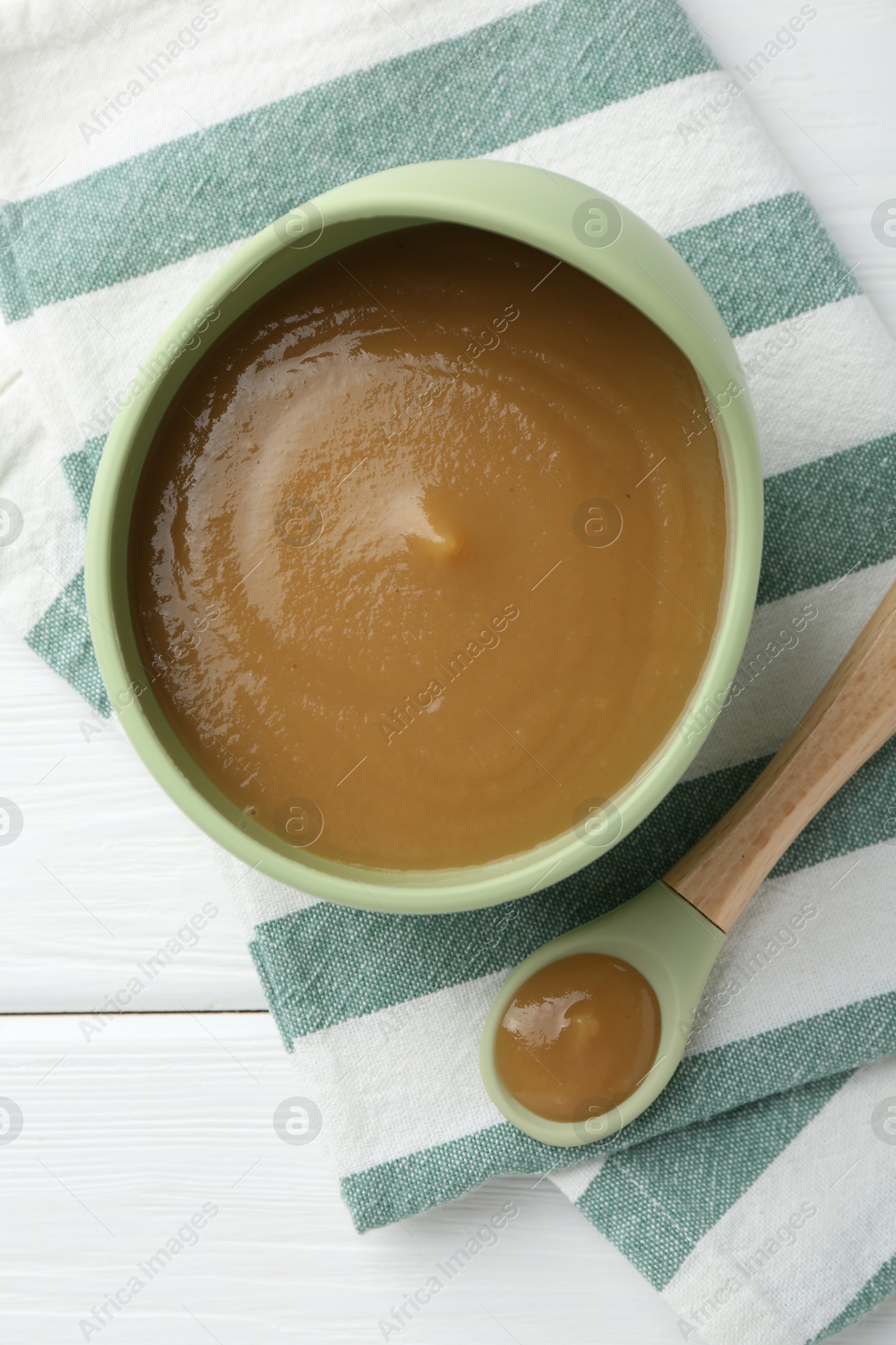 Photo of Delicious baby food in bowl on white wooden table, top view