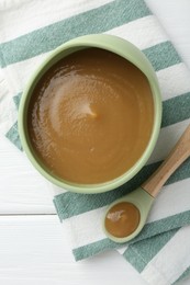 Photo of Delicious baby food in bowl on white wooden table, top view