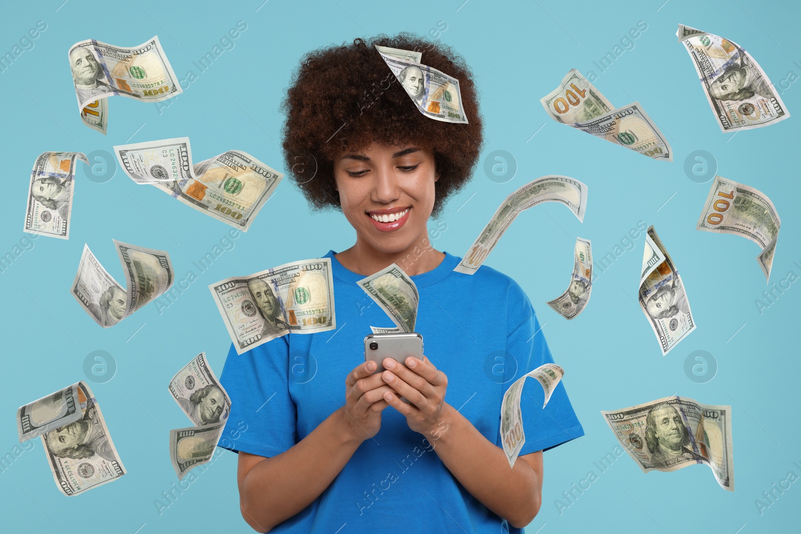 Image of Happy woman using mobile phone under money rain on light blue background