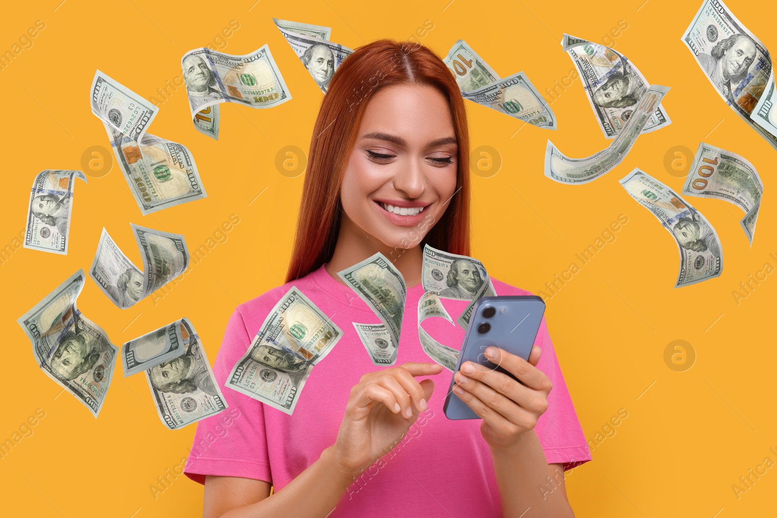 Image of Happy woman using mobile phone on orange background. Money out of device flying around her