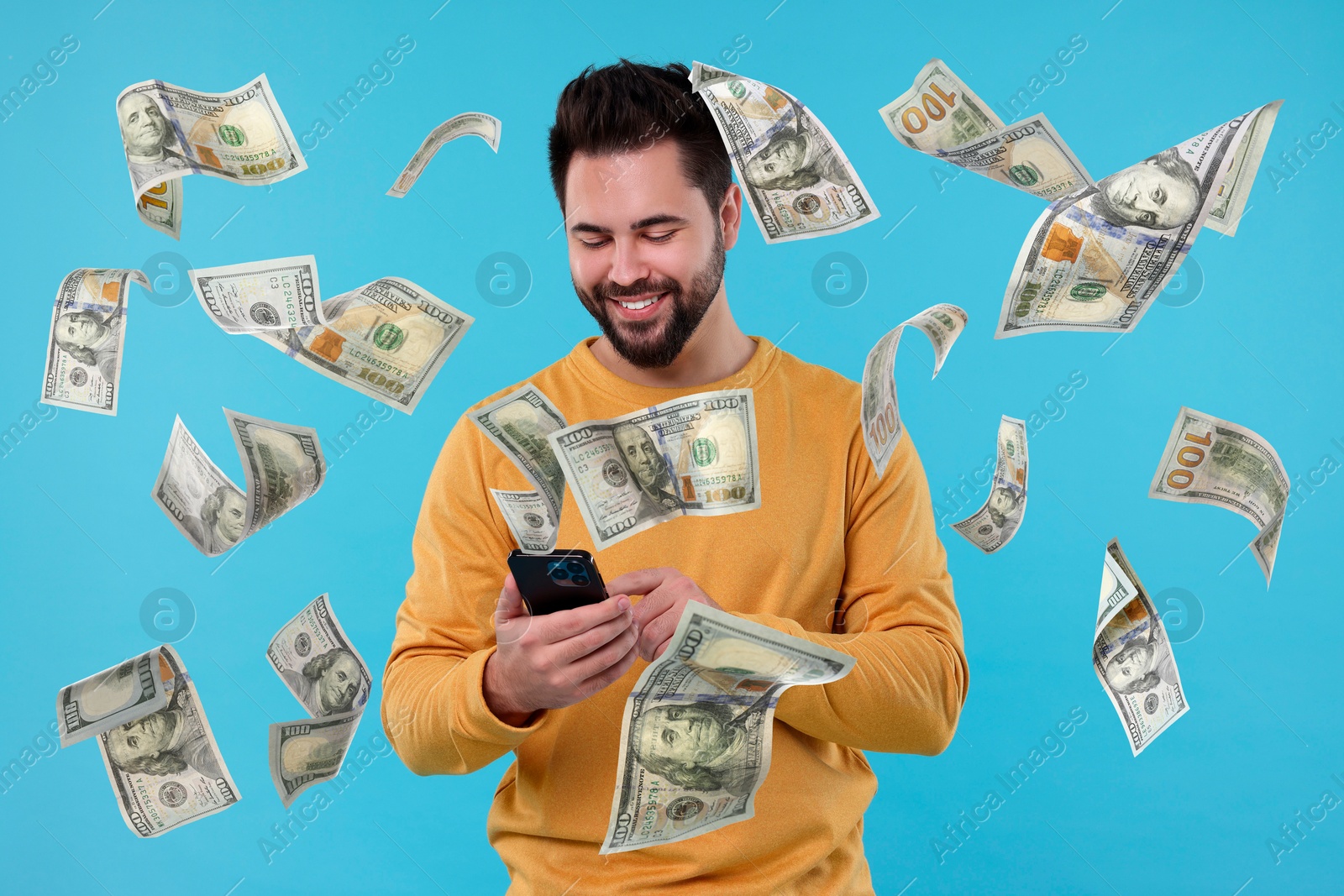 Image of Happy man using mobile phone under money rain on light blue background