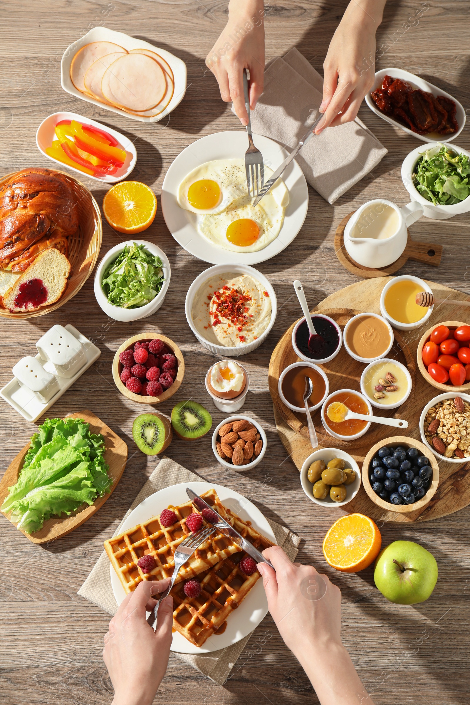 Photo of People having breakfast at wooden table, top view