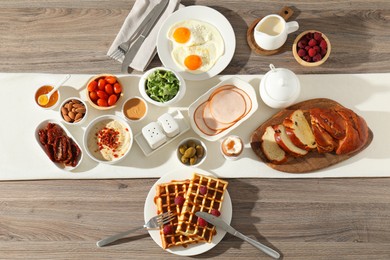 Photo of Different meals served for breakfast on wooden table, flat lay