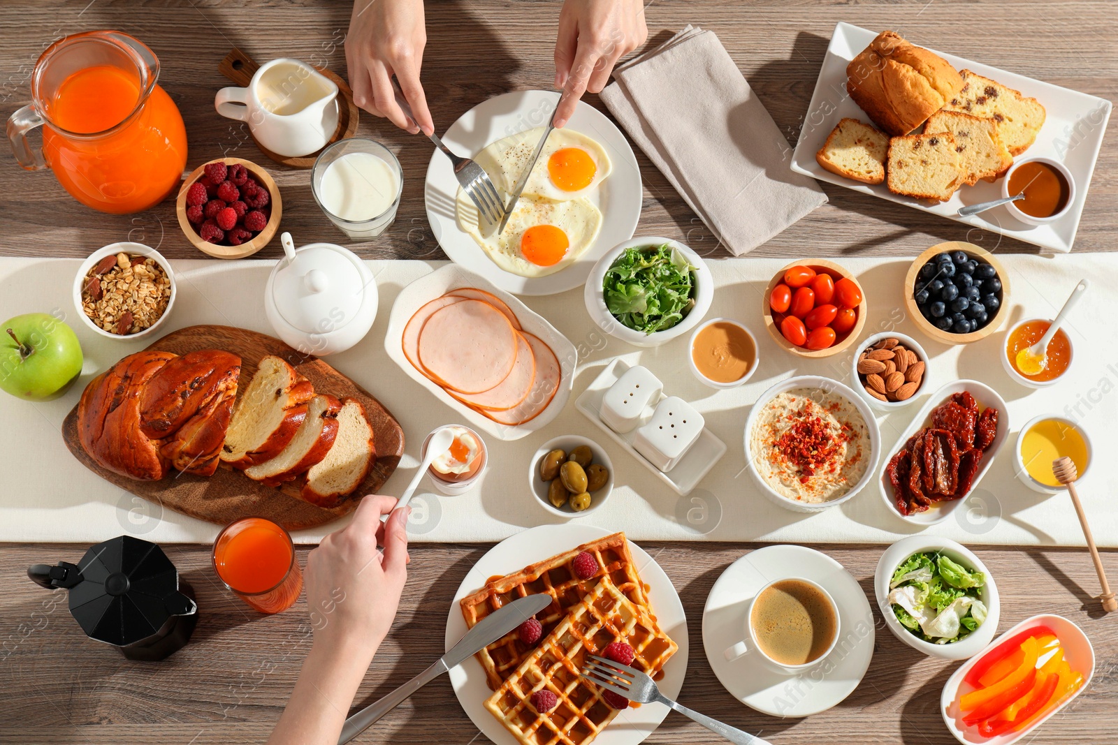 Photo of People having breakfast at wooden table, top view