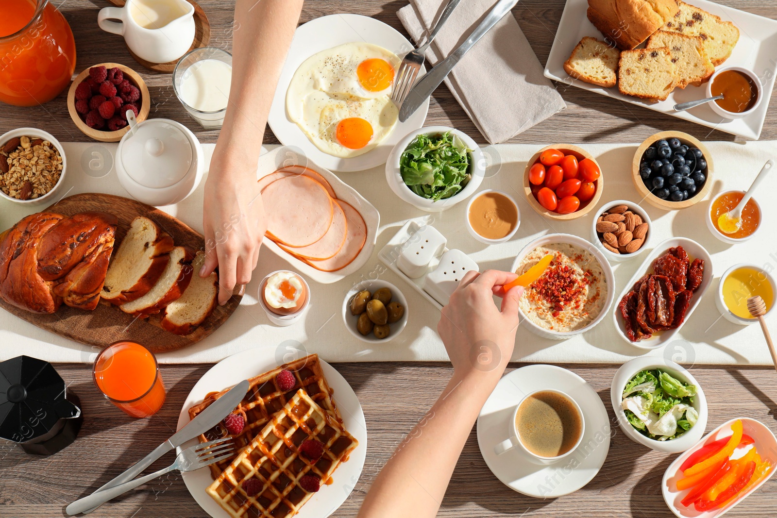 Photo of People having breakfast at wooden table, top view