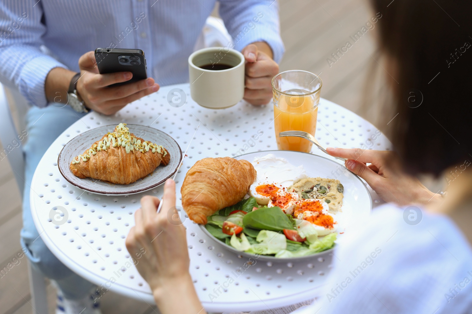 Photo of Couple having tasty breakfast in outdoor cafe, closeup