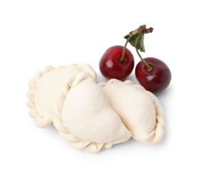 Photo of Frozen dumplings (varenyky) and fresh cherries isolated on white. Ukrainian cuisine