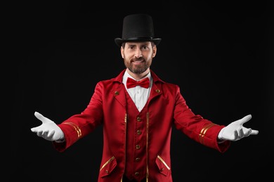 Photo of Portrait of showman in red costume and hat on black background