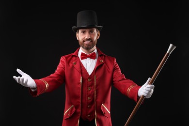 Photo of Portrait of showman in red costume and hat on black background