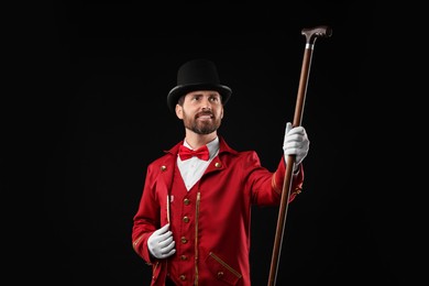 Photo of Portrait of showman in red costume and hat on black background