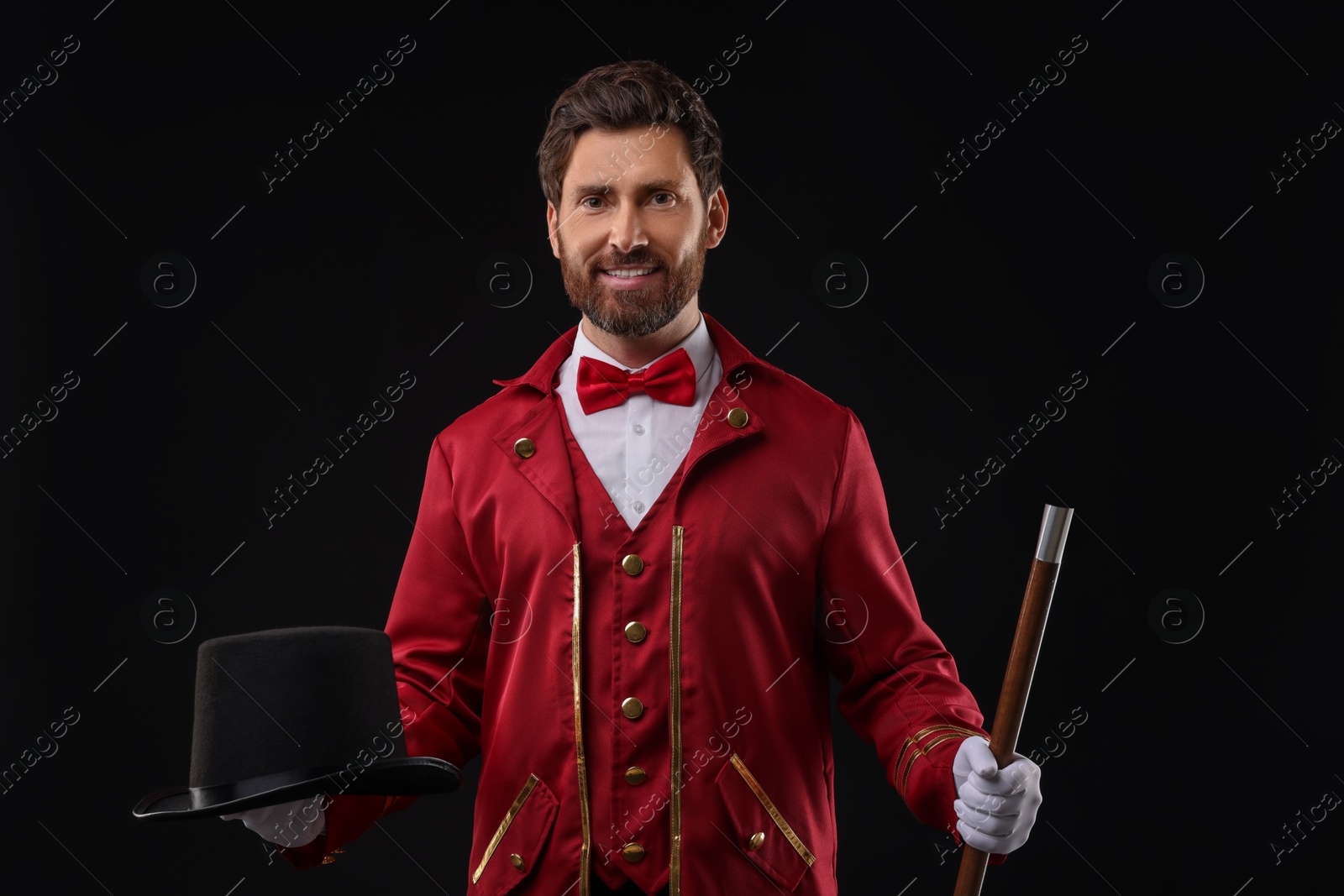 Photo of Portrait of showman in red costume and hat on black background