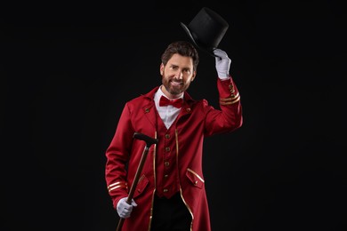 Photo of Portrait of showman in red costume and hat on black background