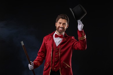 Photo of Portrait of showman in red costume and hat on black background