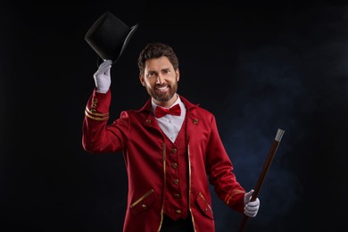 Photo of Portrait of showman in red costume and hat on black background