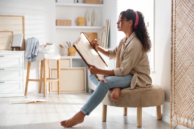 Photo of Beautiful woman drawing portrait with pencil in studio