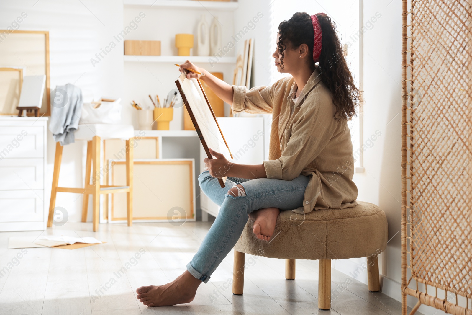 Photo of Beautiful woman drawing picture with pencil in studio