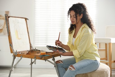 Beautiful woman drawing picture in art studio