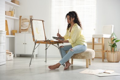 Beautiful woman drawing picture in art studio