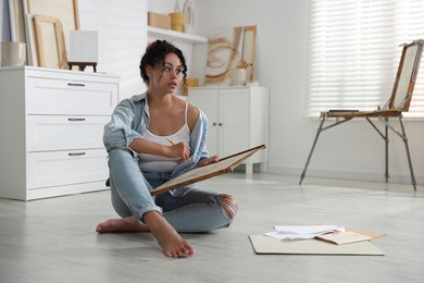 Woman drawing picture with pencil on floor in studio