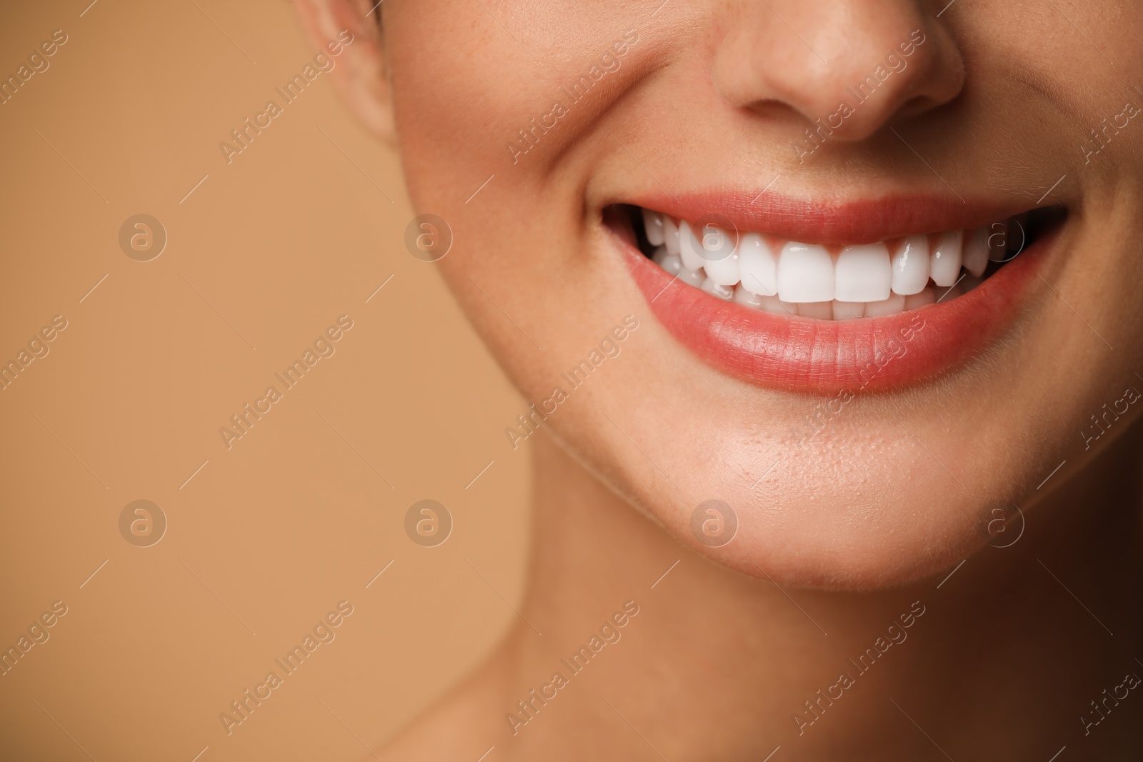 Photo of Smiling woman on beige background, closeup. Dental veneers