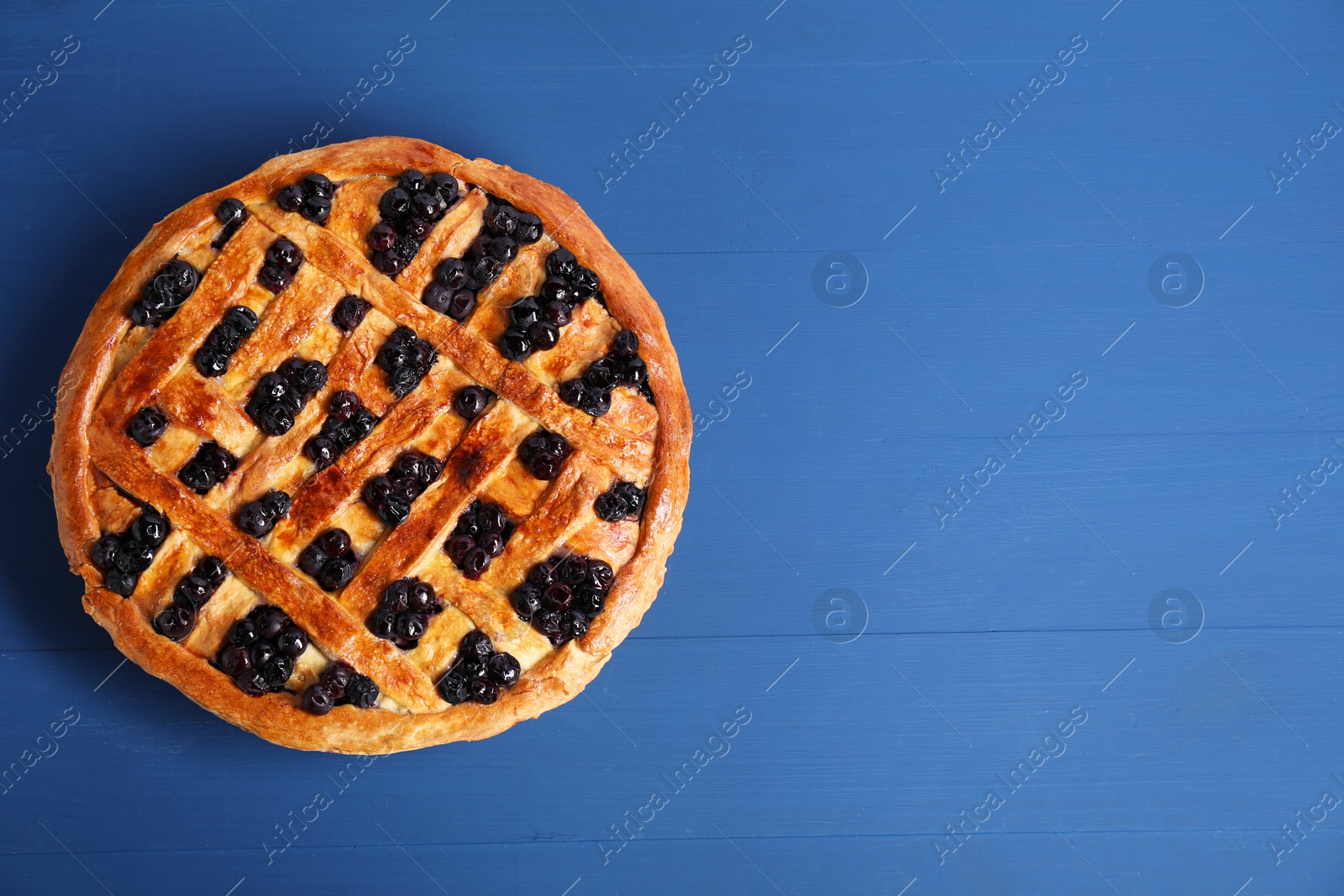 Photo of Tasty homemade pie with blueberries on blue wooden table, top view. Space for text