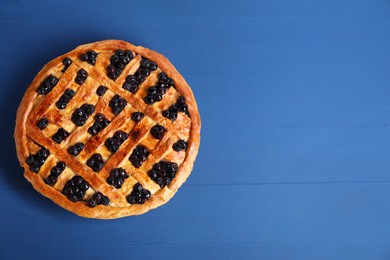 Photo of Tasty homemade pie with blueberries on blue wooden table, top view. Space for text