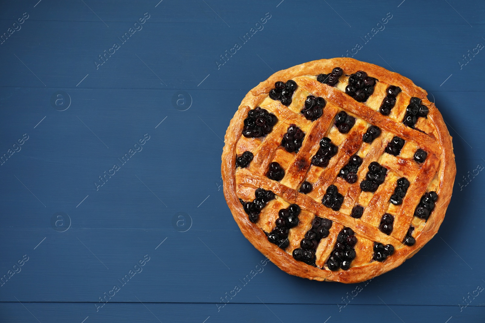 Photo of Tasty homemade pie with blueberries on blue wooden table, top view. Space for text