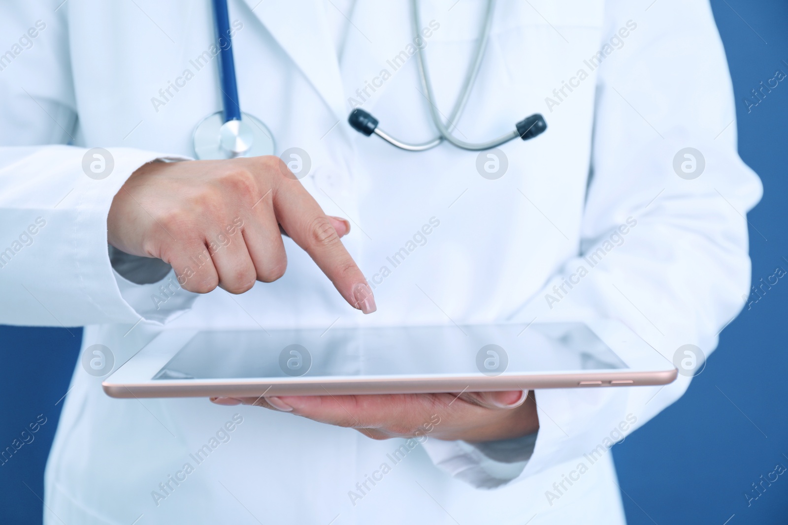 Photo of Doctor with tablet on blue background, closeup view