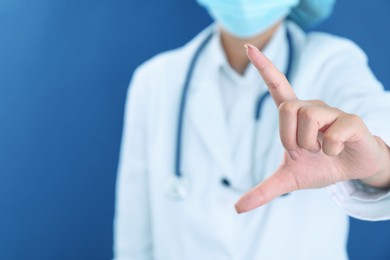 Photo of Doctor holding something on blue background, closeup. Space for text