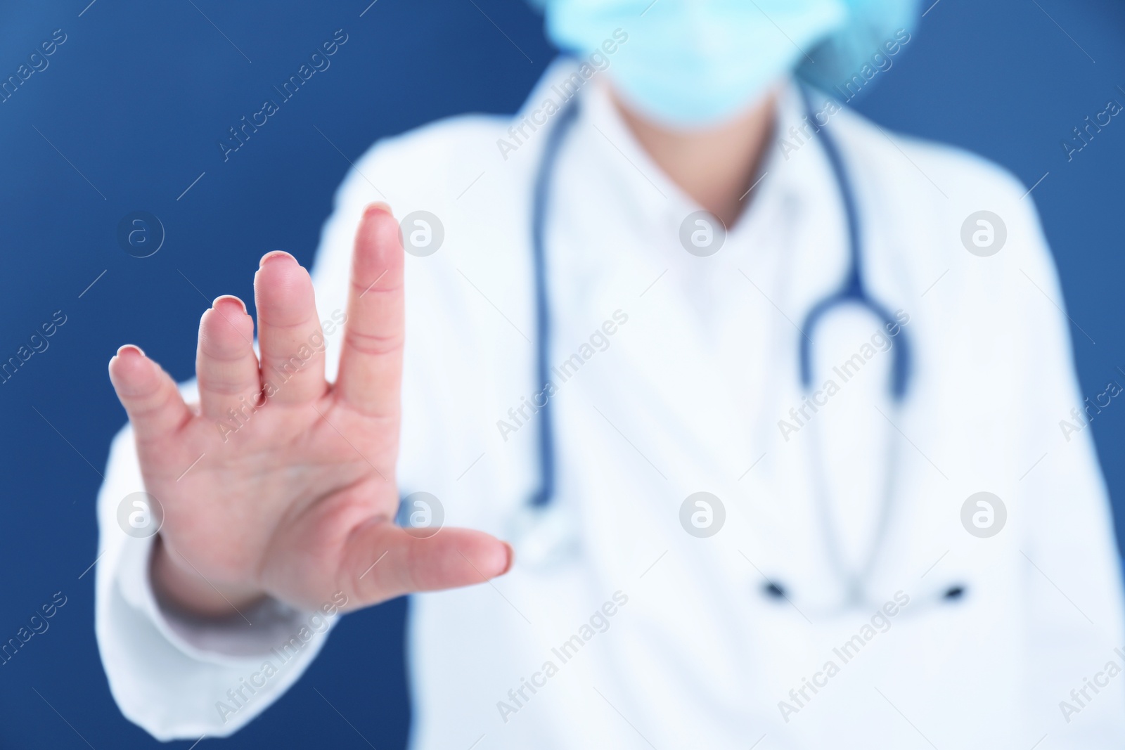 Photo of Doctor holding something on blue background, closeup. Space for text